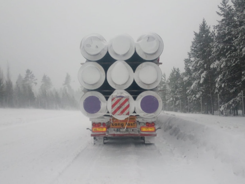 A heavy truck is delivering oversized cargo at winter.